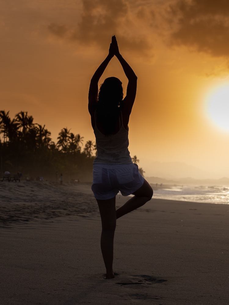Yoga tree pose at sunset